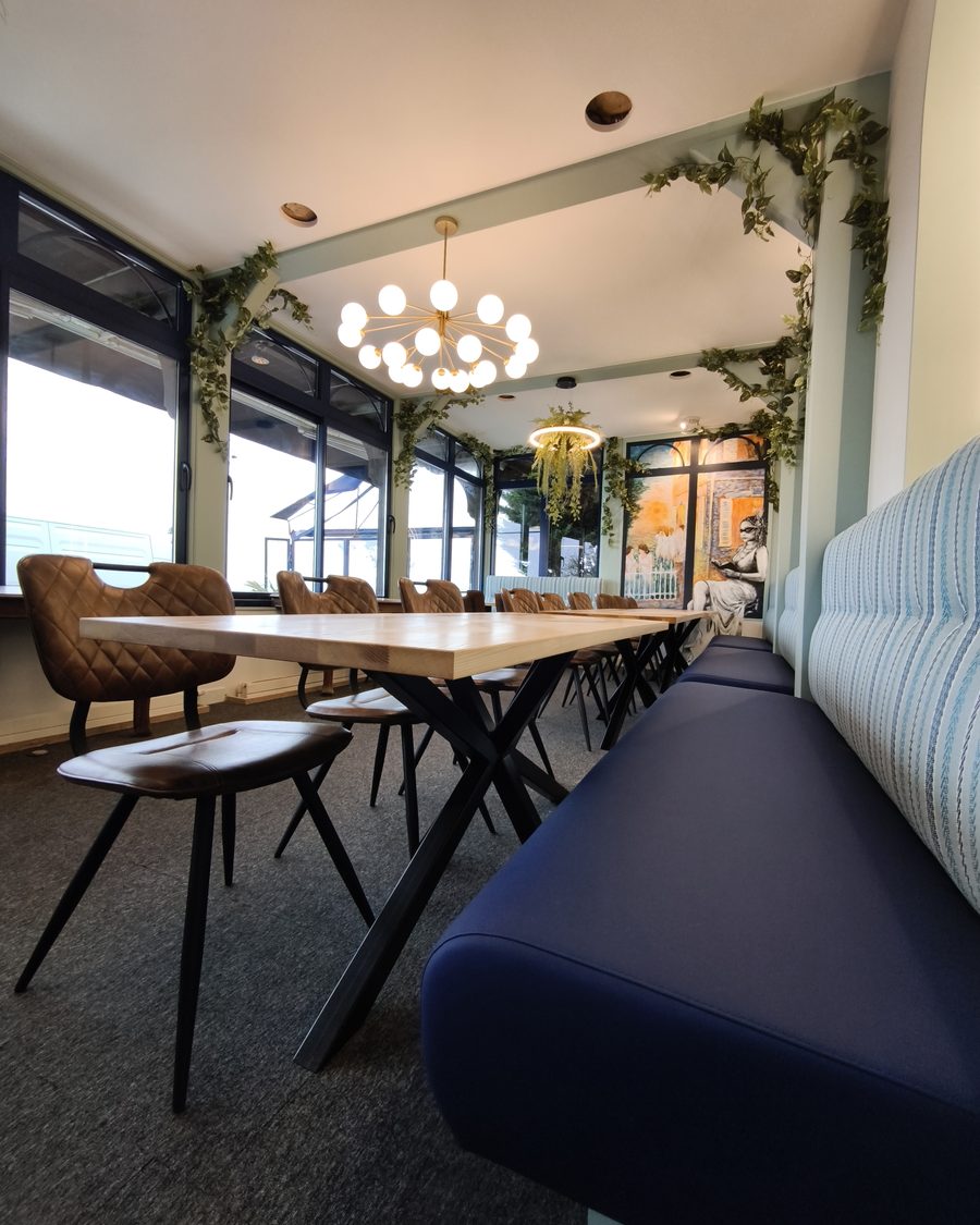 Tables à piètement acier croisé et banquettes sur mesure d’une brasserie